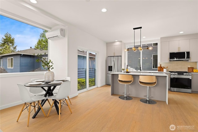 1911C N 120th St, Seattle, WA 98133 - kitchen featuring stainless steel appliances, an AC wall unit, light wood finished floors, decorative backsplash, and recessed lighting