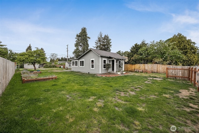 rear view of property with a vegetable garden