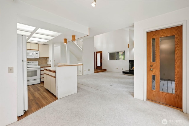 6612 4th St E, Tacoma, WA 98424 - kitchen featuring white appliances, light carpet, a lit fireplace, and a kitchen island