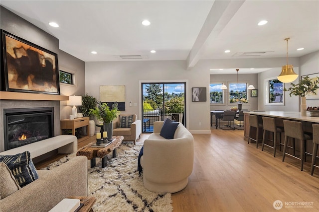 3018 22nd Ave W, Seattle, WA 98199 - living area with light wood-style flooring, recessed lighting, a glass covered fireplace, beamed ceiling, and baseboards