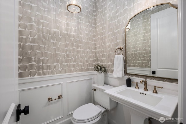 3018 22nd Ave W, Seattle, WA 98199 - bathroom featuring a decorative wall, a sink, toilet, and a wainscoted wall
