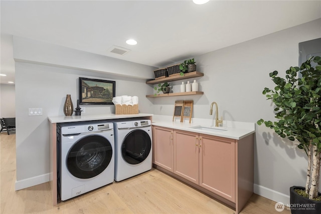 3018 22nd Ave W, Seattle, WA 98199 - washroom featuring washing machine and dryer, light wood finished floors, baseboards, cabinet space, and recessed lighting