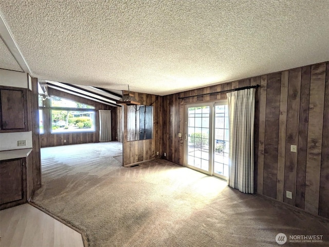201 Union Ave SE Unit 234, Renton, WA 98059 - unfurnished living room featuring wood walls, carpet floors, and a textured ceiling