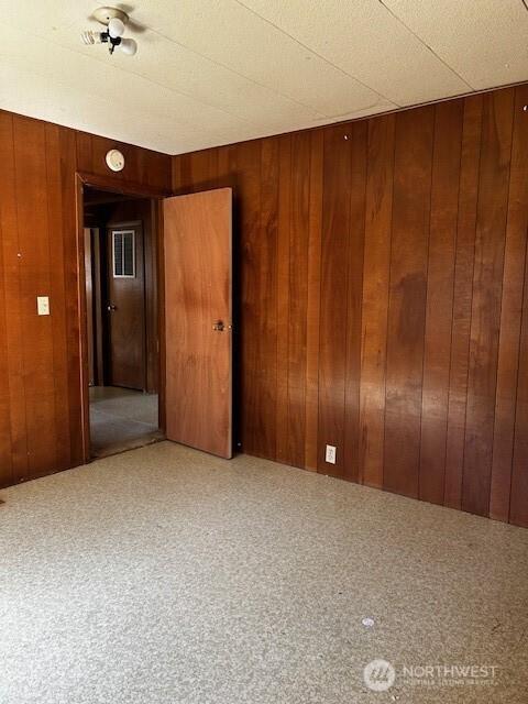 spare room with wooden walls and a smoke detector