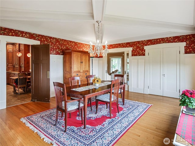 215 N Forest St, Bellingham, WA 98225 - dining area with a chandelier, beamed ceiling, light wood-style flooring, and wallpapered walls