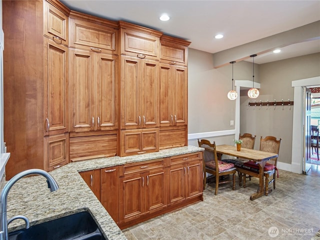 215 N Forest St, Bellingham, WA 98225 - kitchen featuring brown cabinets, light stone countertops, hanging light fixtures, recessed lighting, and stone finish flooring