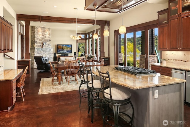 1624 Mallard Ln, Bellevue, WA 98008 - kitchen featuring stainless steel gas stovetop, finished concrete flooring, light stone countertops, a breakfast bar area, and recessed lighting