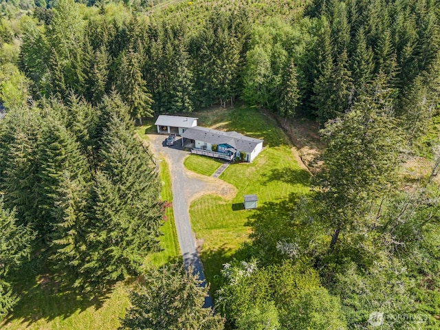 view of subject property with a heavily wooded area