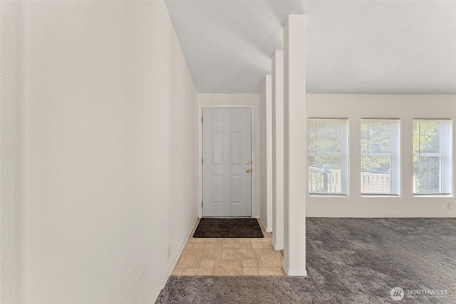 hall featuring carpet floors and baseboards
