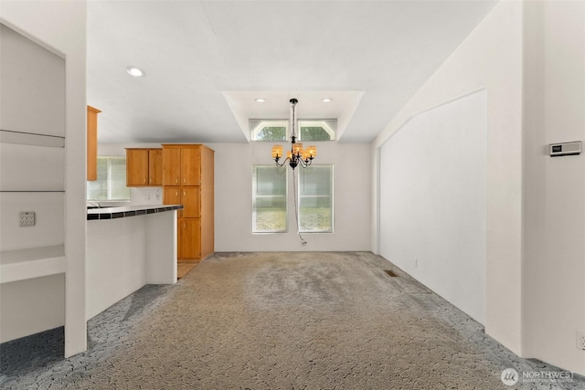 unfurnished living room with a chandelier, light colored carpet, and recessed lighting