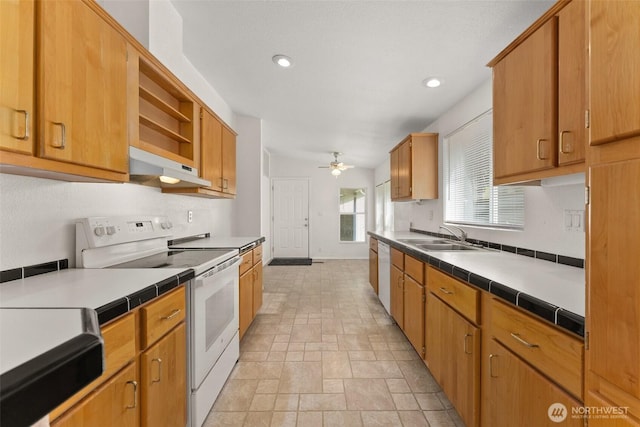 kitchen with white appliances, a sink, under cabinet range hood, ceiling fan, and tile counters
