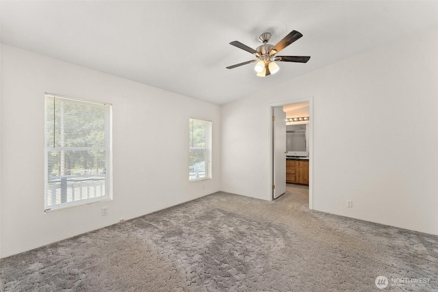 unfurnished bedroom with carpet flooring, vaulted ceiling, a ceiling fan, and ensuite bathroom