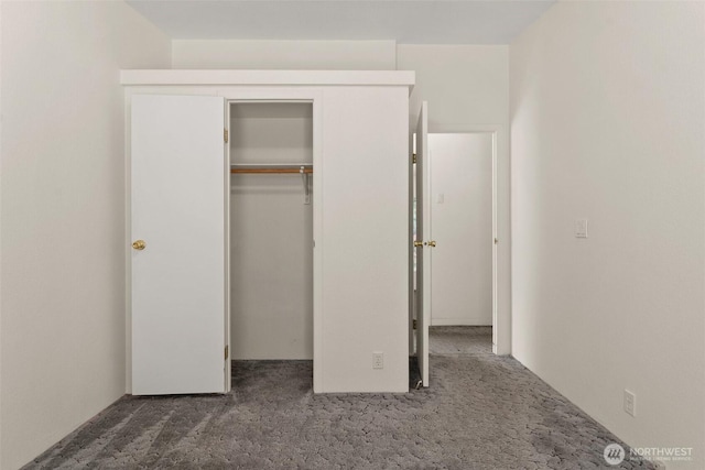 unfurnished bedroom with carpet flooring and a closet