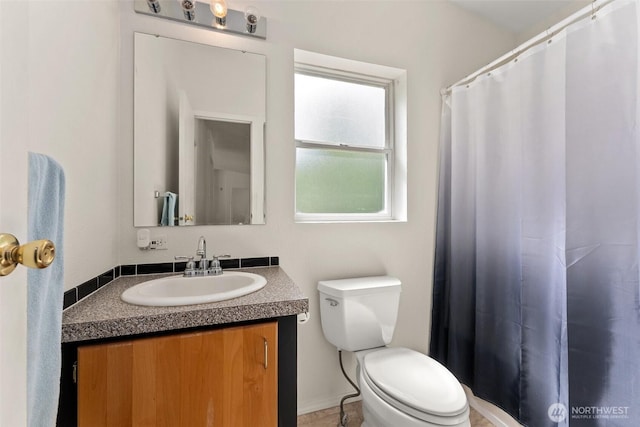 bathroom with toilet, vanity, and a shower with shower curtain