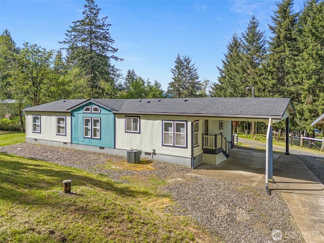 manufactured / mobile home featuring crawl space, driveway, central AC unit, a carport, and a front lawn