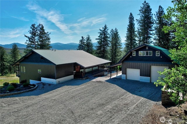 54 Perrow Dr, Winthrop, WA 98862 - view of front of home with a mountain view, an outdoor structure, driveway, a detached garage, and metal roof