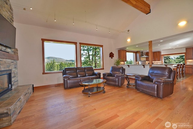 54 Perrow Dr, Winthrop, WA 98862 - living area with light wood finished floors, a stone fireplace, beam ceiling, baseboards, and recessed lighting