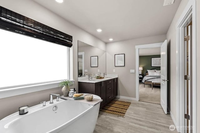 11555 SE 84th St Unit 47, Newcastle, WA 98056 - full bath featuring ensuite bath, a freestanding bath, double vanity, wood finished floors, and recessed lighting