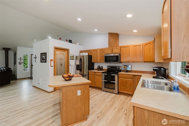 760 Lewis Rd W, Seabeck, WA 98380 - kitchen featuring appliances with stainless steel finishes, a sink, light countertops, light wood-style floors, and a kitchen island