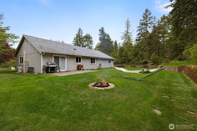 760 Lewis Rd W, Seabeck, WA 98380 - back of property with an outdoor fire pit, a lawn, and a patio area