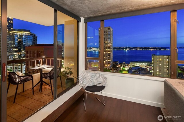 balcony with a view of city lights and a water view