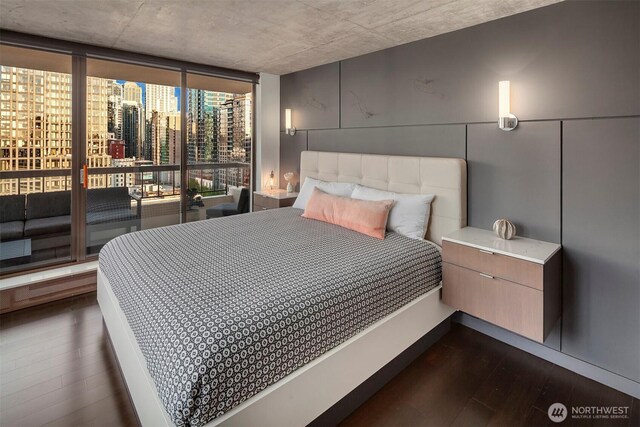 bedroom featuring dark wood-style flooring and floor to ceiling windows