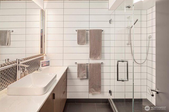 full bath with a stall shower, vanity, and tile patterned flooring