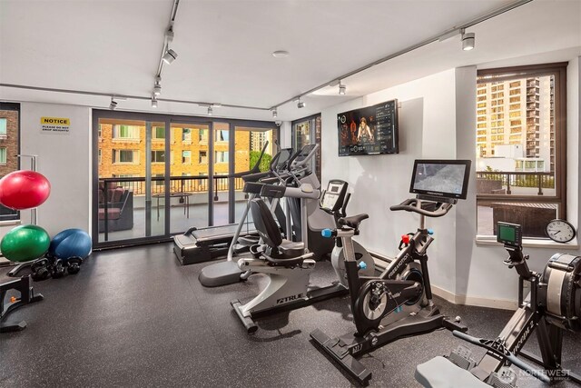 workout area featuring track lighting and baseboards