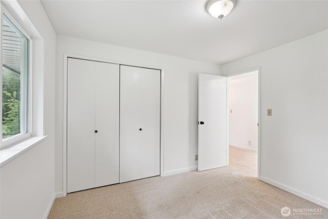 unfurnished bedroom with baseboards, a closet, and carpet floors