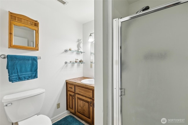 bathroom with a stall shower, toilet, and vanity