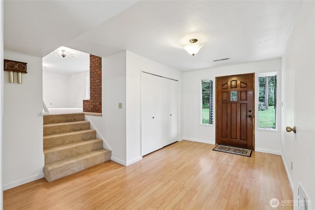 entryway featuring light wood-style floors, stairway, and baseboards