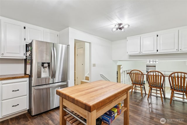 kitchen featuring stainless steel refrigerator with ice dispenser, white cabinets, dark wood finished floors, and butcher block countertops