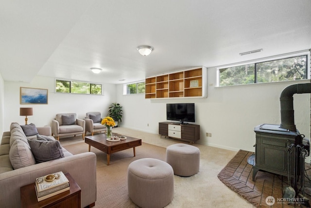 carpeted living area with a wood stove