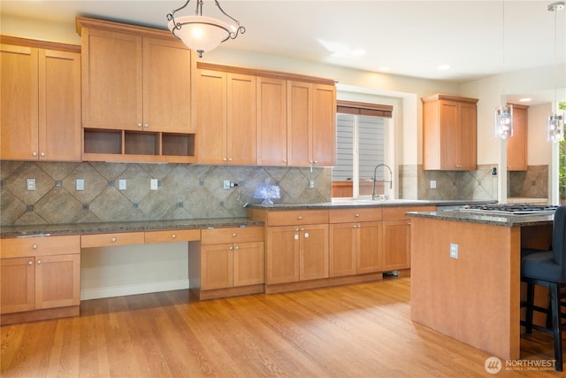 15927 35th Dr SE, Bothell, WA 98012 - kitchen with light wood-style flooring, a kitchen bar, backsplash, recessed lighting, and dark stone counters