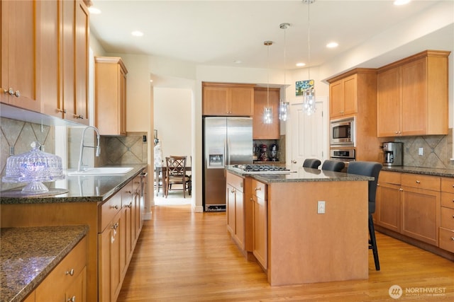 15927 35th Dr SE, Bothell, WA 98012 - kitchen featuring stainless steel appliances, decorative backsplash, a center island, light wood-style floors, and dark stone counters