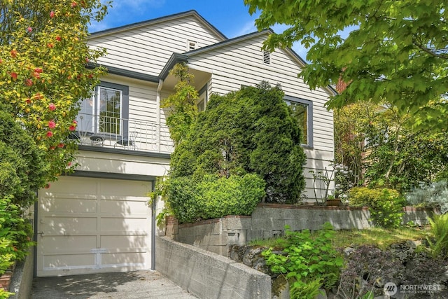 view of property exterior with concrete driveway and a garage