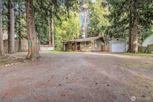 21843 SE Crest Ln SE, Yelm, WA 98597 - view of front facade featuring a garage, an outdoor structure, a porch, fence, and dirt driveway