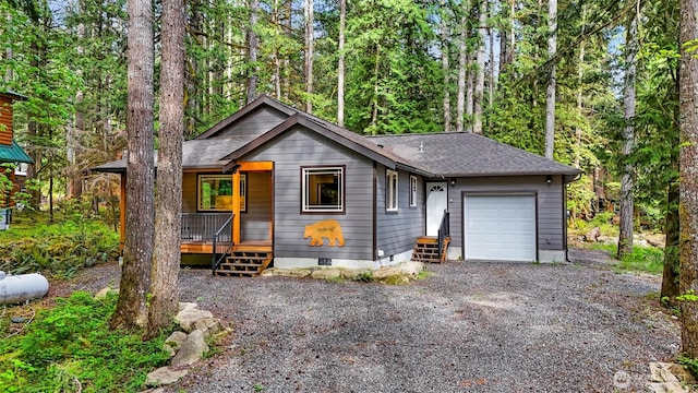 7468 Glacier Springs Dr, Deming, WA 98244 - view of front of home featuring crawl space, a garage, a porch, gravel driveway, and roof with shingles