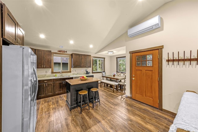 7468 Glacier Springs Dr, Deming, WA 98244 - kitchen featuring stainless steel fridge, a wall unit AC, dark brown cabinetry, light countertops, and dark wood-style flooring