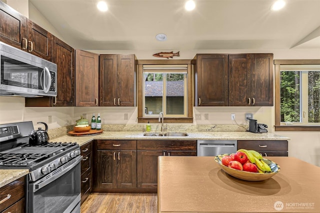 7468 Glacier Springs Dr, Deming, WA 98244 - kitchen featuring appliances with stainless steel finishes, a sink, dark brown cabinetry, light wood-style flooring, and recessed lighting