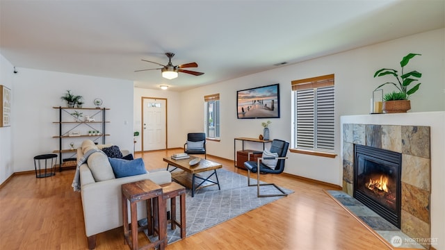 28843 213th Ct SE, Kent, WA 98042 - living area featuring wood finished floors, a tile fireplace, a ceiling fan, and baseboards