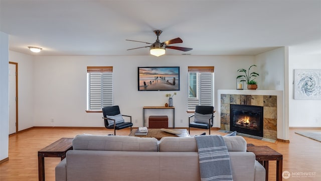 28843 213th Ct SE, Kent, WA 98042 - living room with a ceiling fan, light wood-style floors, a tiled fireplace, and baseboards