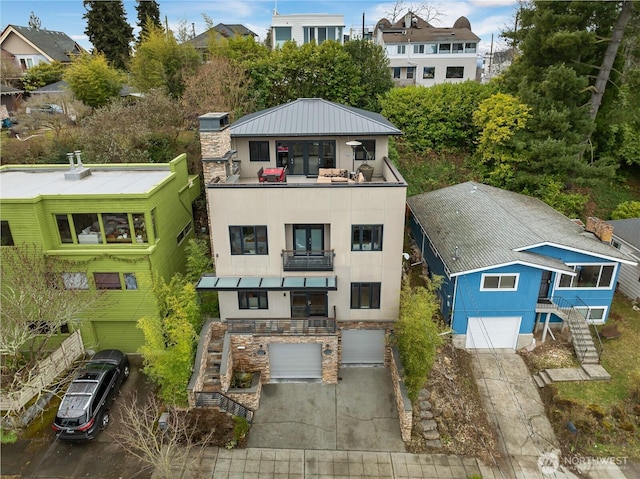 view of property with stairs, a garage, and concrete driveway