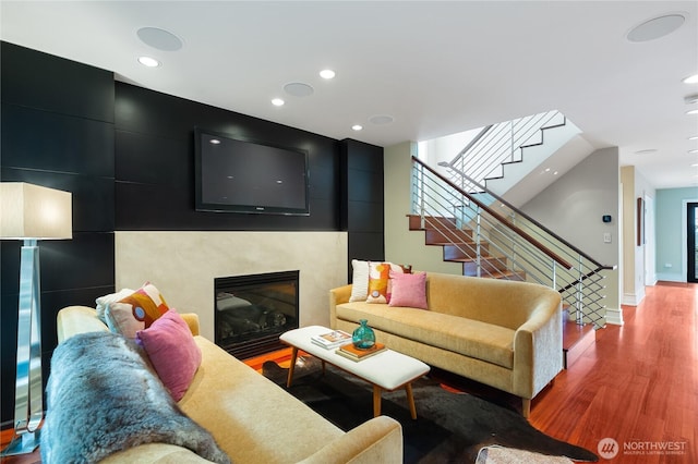 living room with stairway, wood finished floors, a fireplace, and recessed lighting
