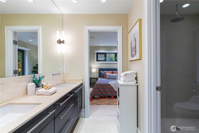 ensuite bathroom featuring a shower stall, double vanity, tile patterned floors, and recessed lighting