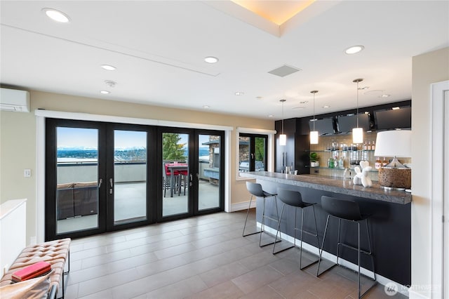 kitchen with a wall mounted AC, a breakfast bar area, french doors, recessed lighting, and a peninsula