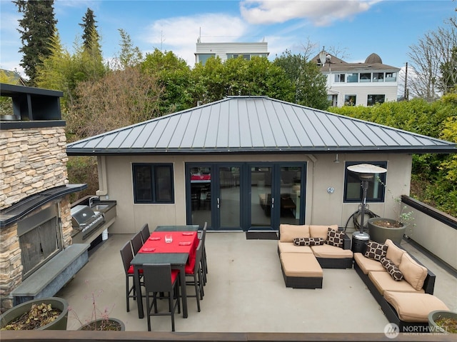 rear view of house featuring a standing seam roof, area for grilling, an outdoor living space, metal roof, and stucco siding