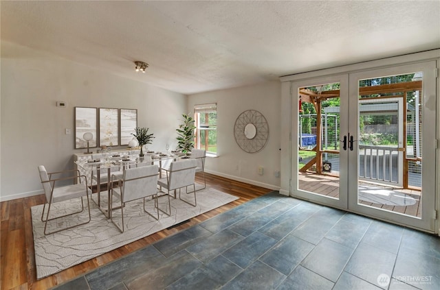 dining room with baseboards, french doors, wood finished floors, and a textured ceiling