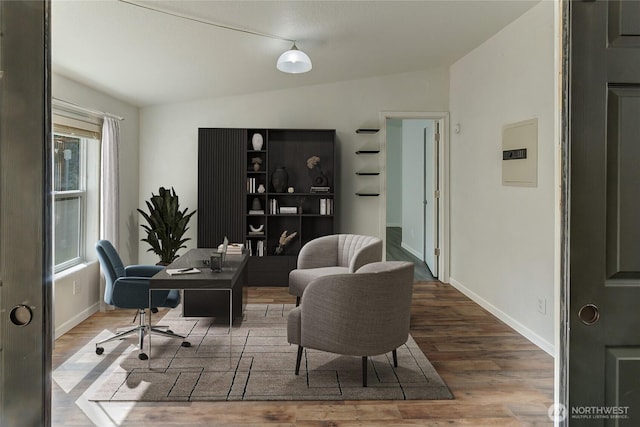 office space with vaulted ceiling, wood finished floors, and baseboards