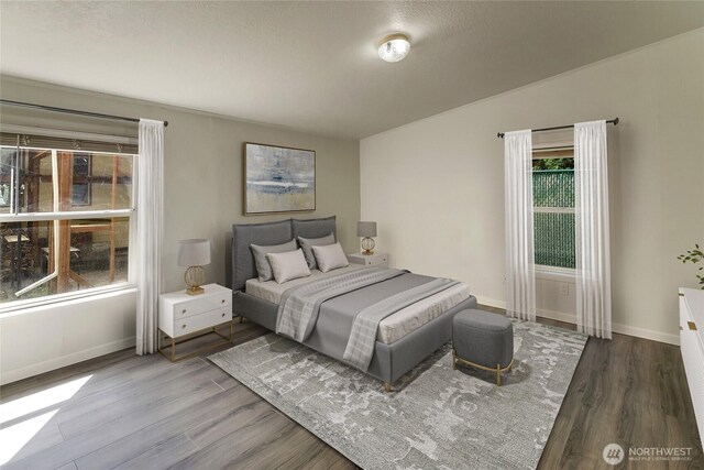 bedroom featuring wood finished floors and baseboards